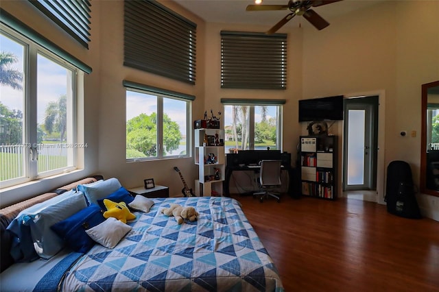 bedroom with dark wood-style floors and a towering ceiling