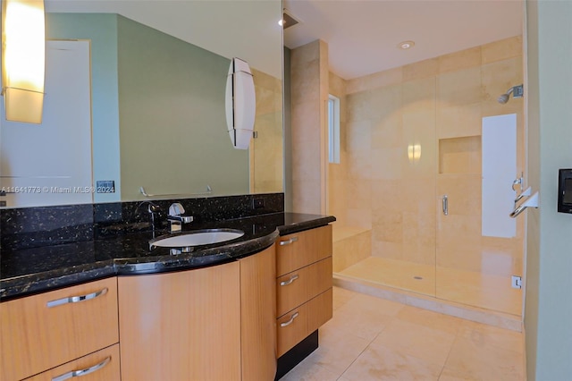 bathroom with a stall shower, tile patterned flooring, and vanity