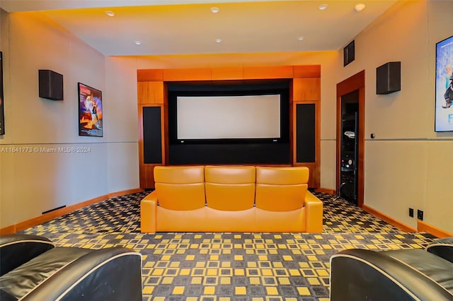 home theater with dark colored carpet, visible vents, and baseboards