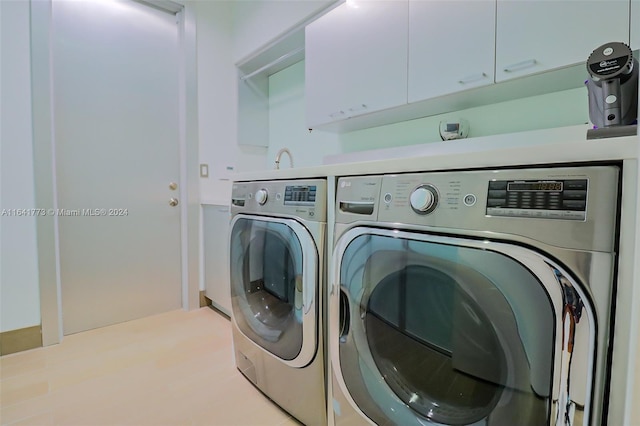 washroom with cabinet space and separate washer and dryer