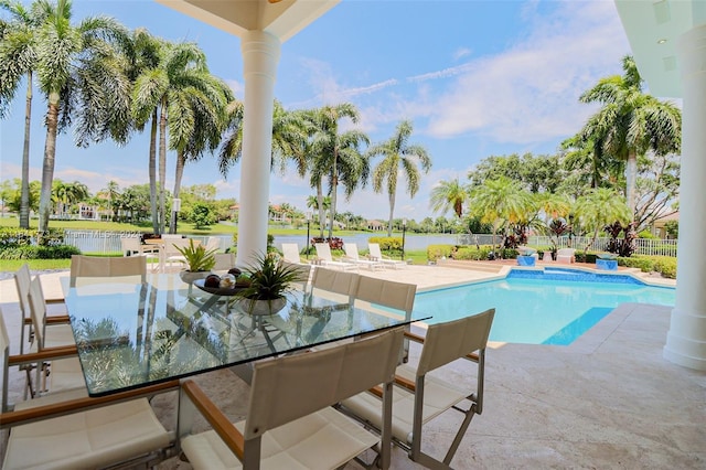 view of pool with a fenced in pool, a patio, a water view, outdoor dining space, and fence