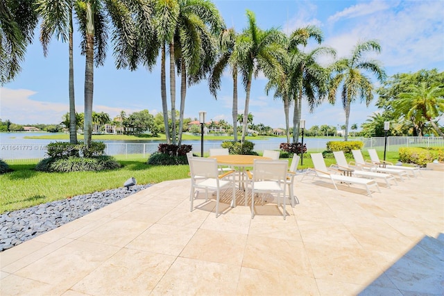 view of patio / terrace featuring a water view and fence