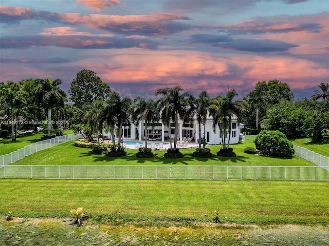 view of property's community with a pool, a fenced backyard, and a lawn