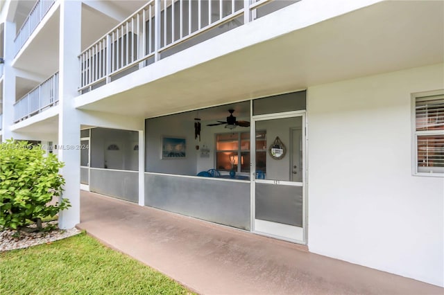 entrance to property with ceiling fan and a balcony