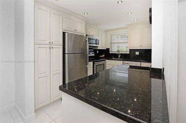 kitchen with appliances with stainless steel finishes, dark stone countertops, backsplash, and kitchen peninsula