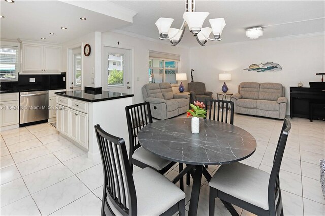 tiled dining area featuring crown molding and an inviting chandelier