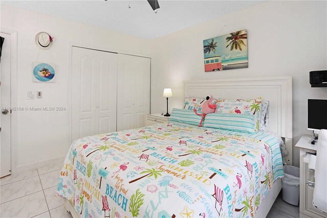 tiled bedroom featuring ceiling fan and a closet