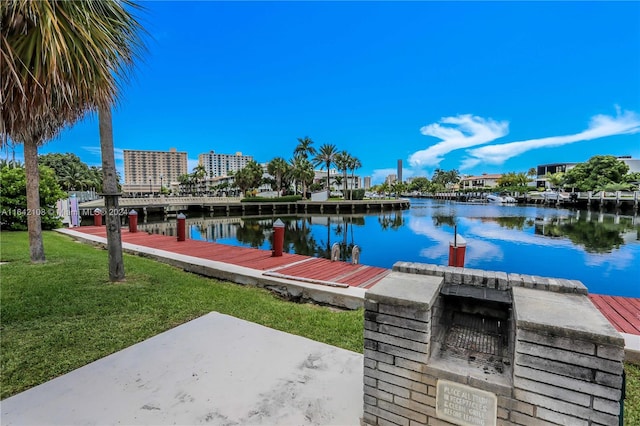 dock area with a lawn and a water view