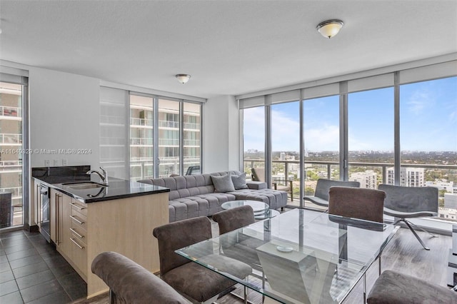 tiled dining room with sink, a textured ceiling, floor to ceiling windows, and wine cooler