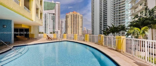 community pool featuring a view of city and a patio area