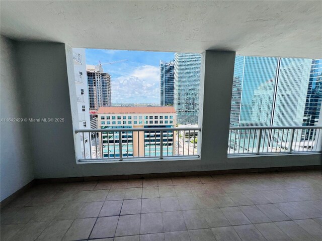 unfurnished room with a textured ceiling and tile patterned floors