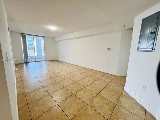 empty room with light tile patterned flooring and floor to ceiling windows