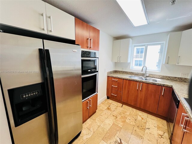 kitchen featuring white cabinetry, sink, and appliances with stainless steel finishes