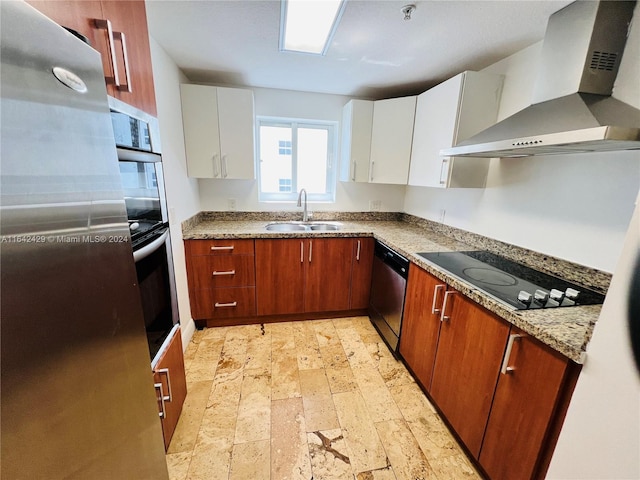 kitchen with black electric stovetop, wall chimney range hood, sink, stainless steel dishwasher, and white cabinetry