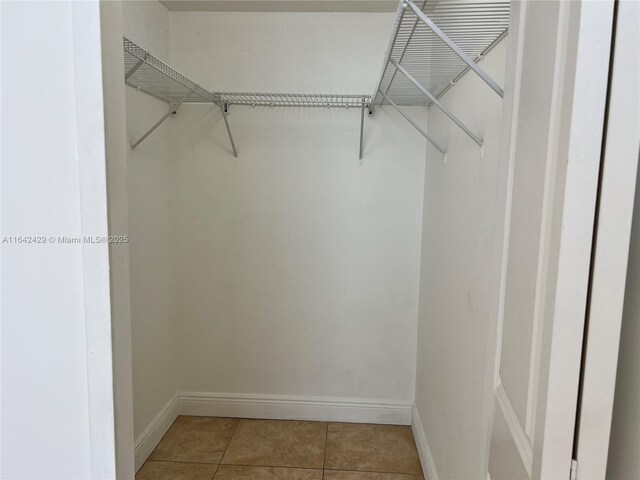 walk in closet with tile patterned floors