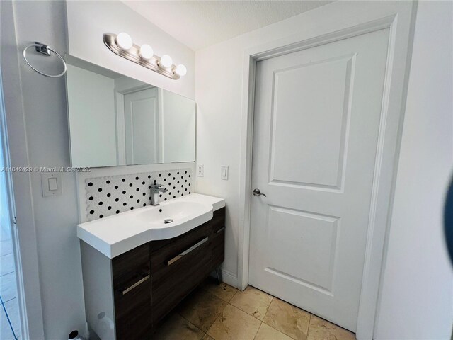 bathroom featuring vanity and tasteful backsplash