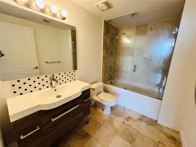 full bathroom with vanity, toilet, and bath / shower combo with glass door