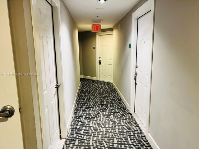 hallway with dark colored carpet