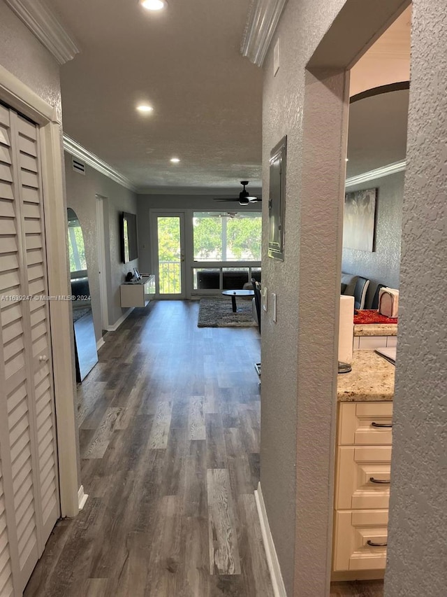 hall with dark wood-type flooring and ornamental molding