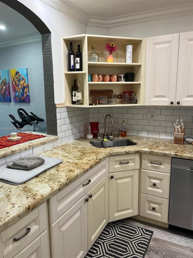 kitchen featuring sink, light stone counters, tasteful backsplash, ornamental molding, and dishwasher