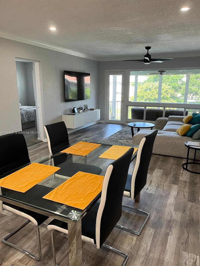 dining area with hardwood / wood-style flooring, crown molding, a healthy amount of sunlight, and a textured ceiling