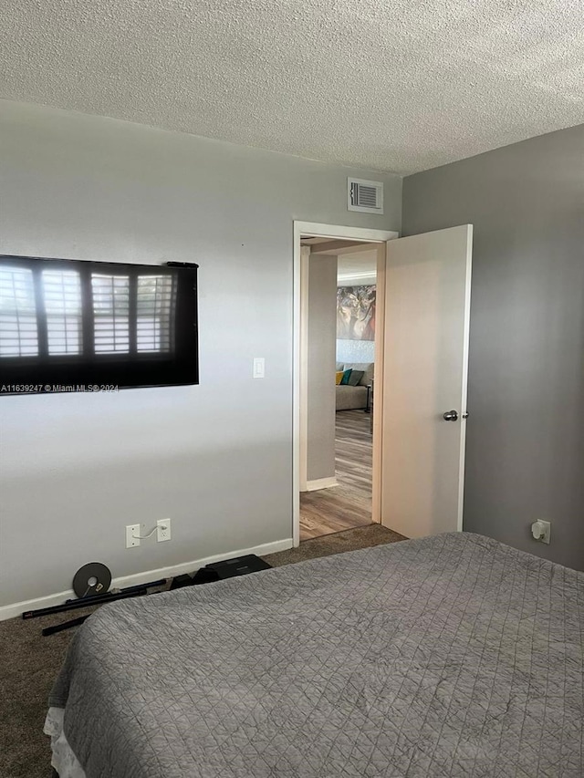 carpeted bedroom featuring a textured ceiling