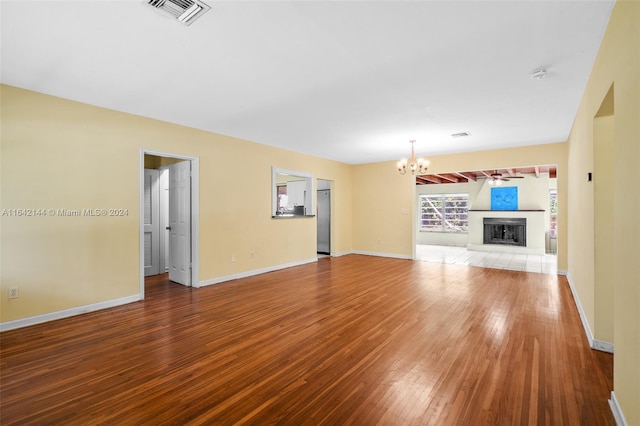 unfurnished living room with hardwood / wood-style flooring and an inviting chandelier