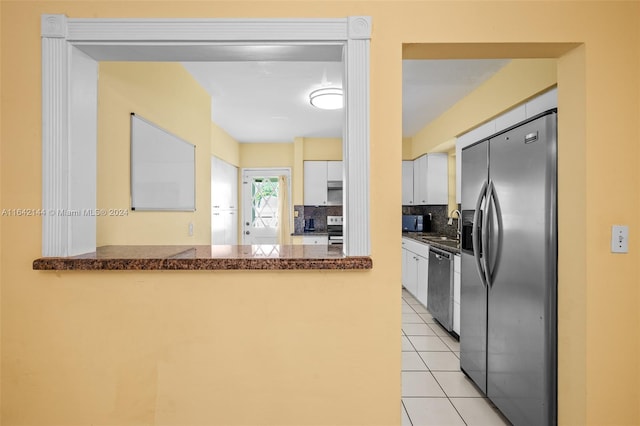 kitchen with white cabinetry, sink, backsplash, kitchen peninsula, and appliances with stainless steel finishes