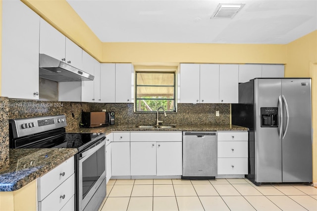 kitchen featuring white cabinets, appliances with stainless steel finishes, dark stone countertops, and sink