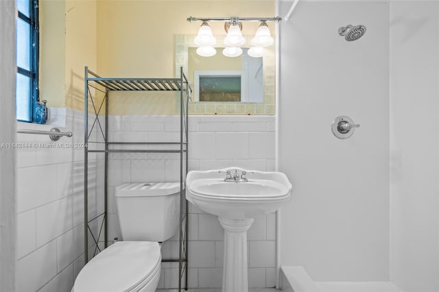 bathroom with tile walls and toilet