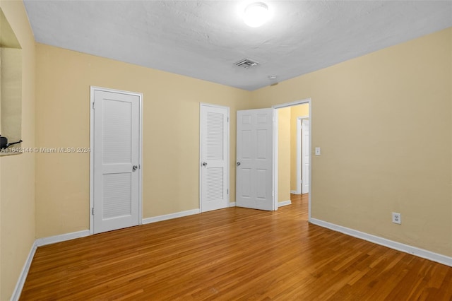 unfurnished bedroom with wood-type flooring and a textured ceiling