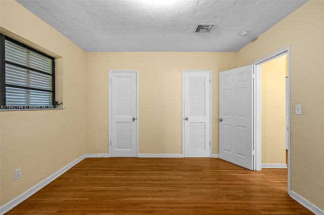 unfurnished bedroom featuring a textured ceiling and hardwood / wood-style flooring