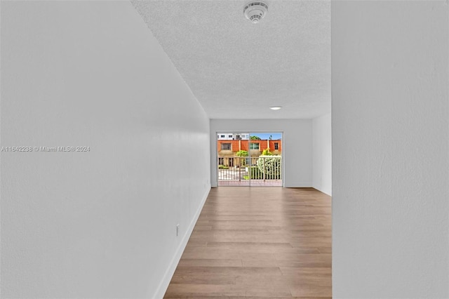 hall featuring a textured ceiling and light wood-type flooring