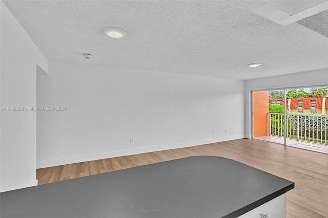 unfurnished living room featuring a textured ceiling and light wood-type flooring