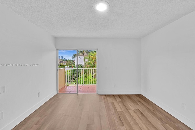 empty room featuring light hardwood / wood-style flooring and a textured ceiling