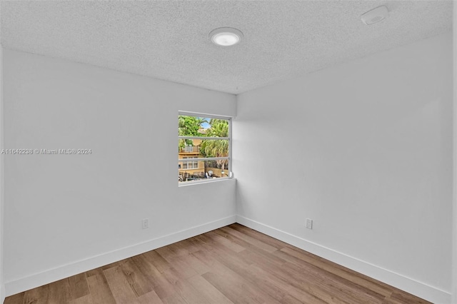 empty room featuring hardwood / wood-style floors and a textured ceiling