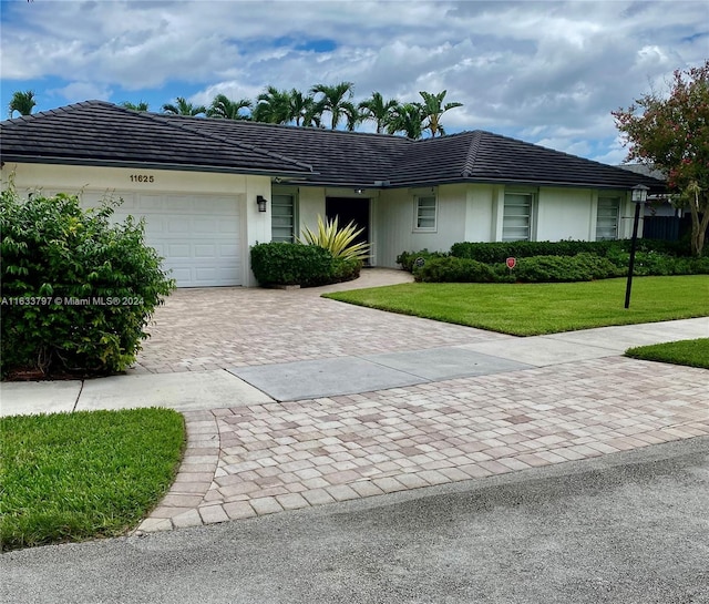 single story home with a garage and a front lawn