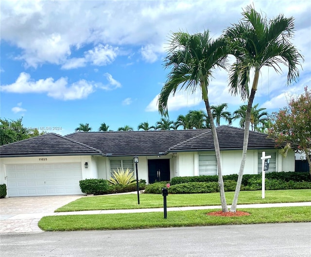 ranch-style home with a garage and a front lawn