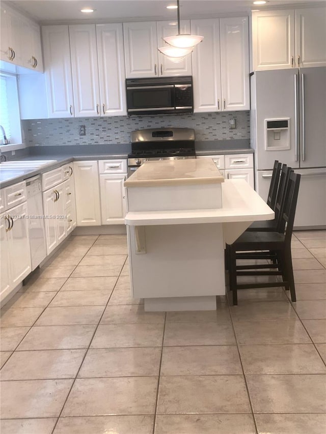 kitchen with decorative backsplash, a kitchen island, light tile patterned floors, sink, and white appliances