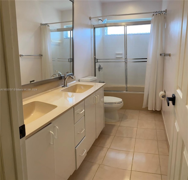 full bathroom with tile patterned floors, bathing tub / shower combination, dual vanity, and toilet