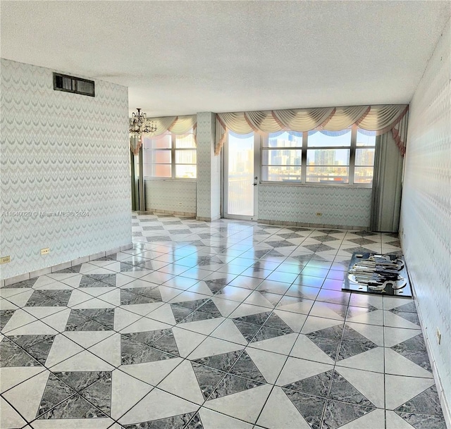 tiled spare room featuring a textured ceiling