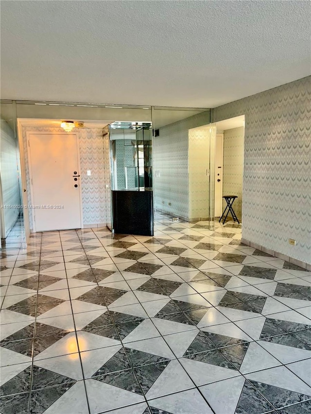 interior space featuring light tile patterned flooring and a textured ceiling