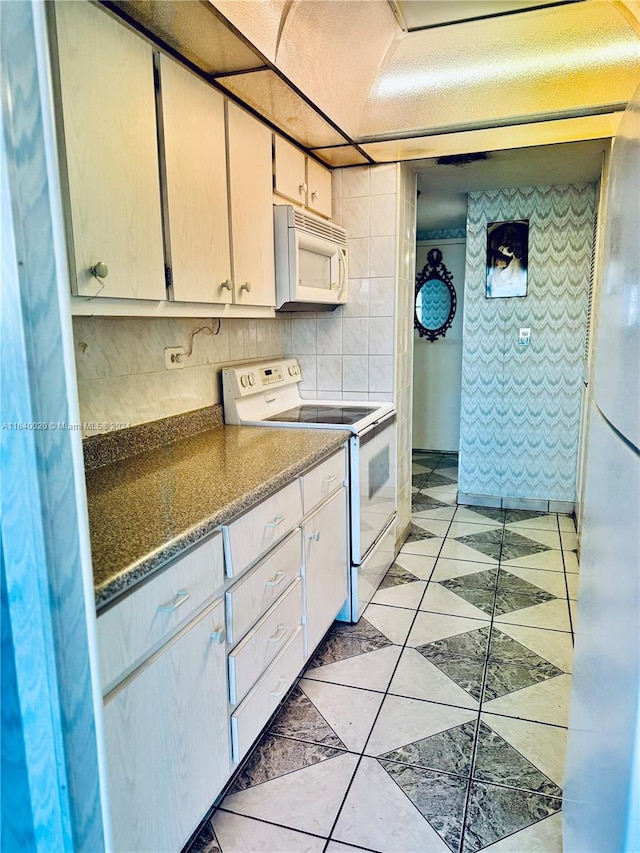 kitchen featuring tile walls, backsplash, light tile patterned flooring, and white appliances