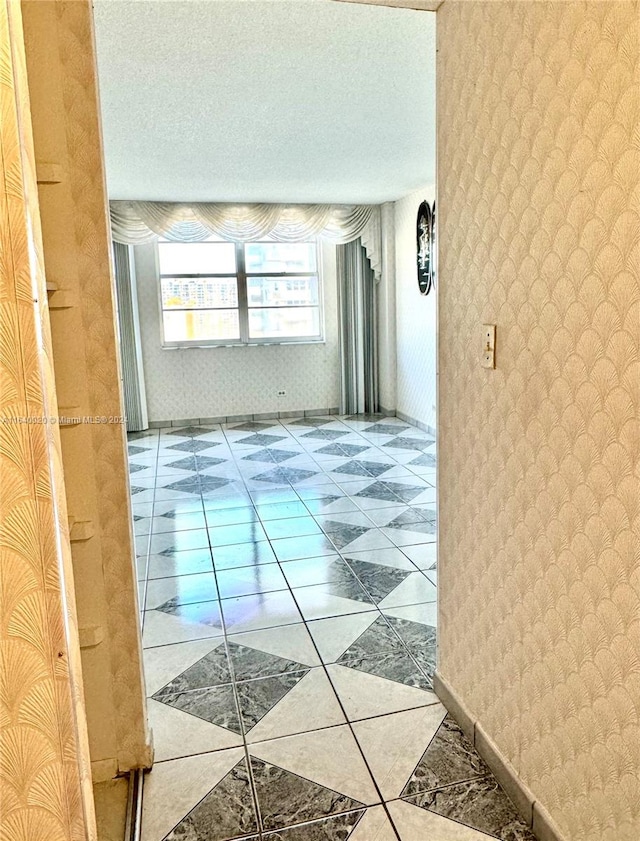 hall featuring a textured ceiling and light tile patterned flooring