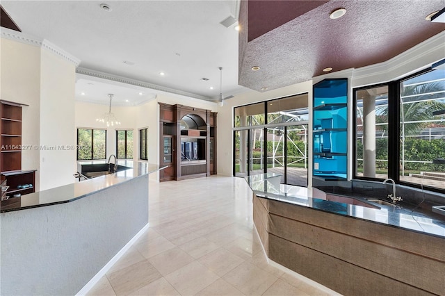 kitchen with a wealth of natural light, a chandelier, sink, and hanging light fixtures