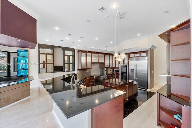 kitchen featuring a kitchen island, light tile patterned floors, decorative light fixtures, and appliances with stainless steel finishes