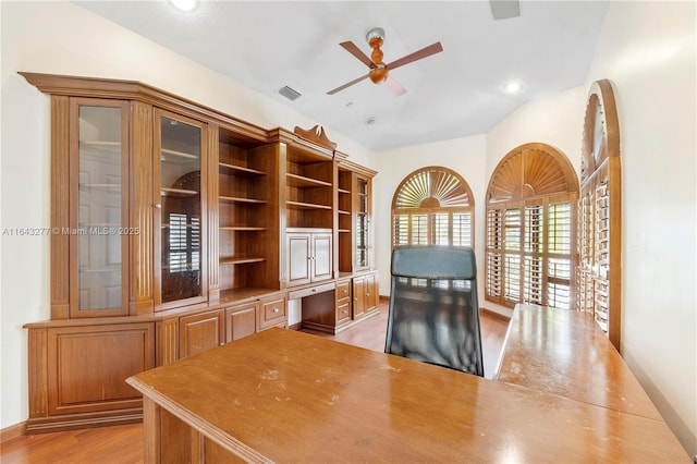 home office featuring ceiling fan, light hardwood / wood-style floors, built in desk, and lofted ceiling