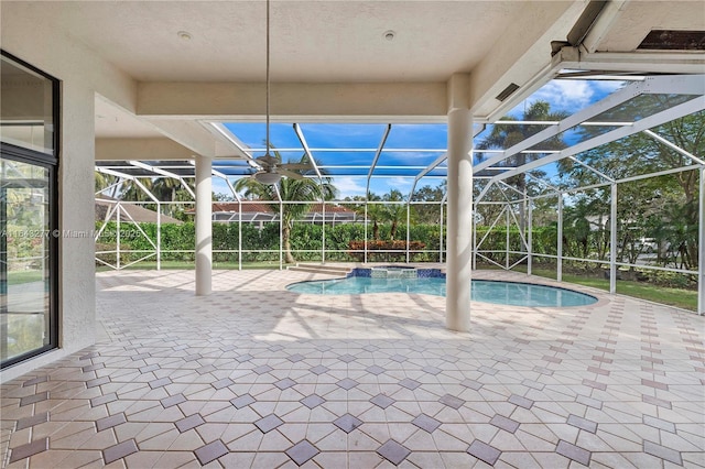 view of pool with glass enclosure, a patio area, and an in ground hot tub