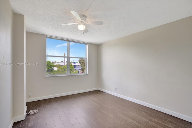 empty room featuring ceiling fan, a textured ceiling, and wood-type flooring