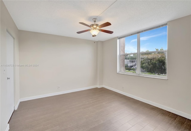 unfurnished room with a textured ceiling, ceiling fan, and wood-type flooring